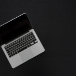 top side down angle on a laptop computer sitting on a black surface