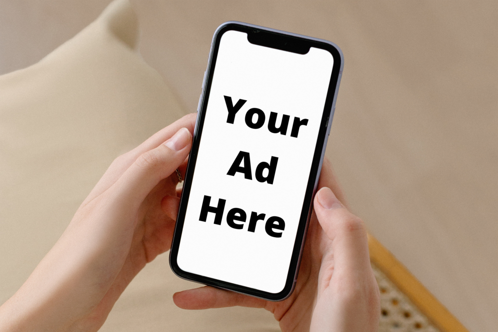 Person holding a cell phone with available ad space displayed