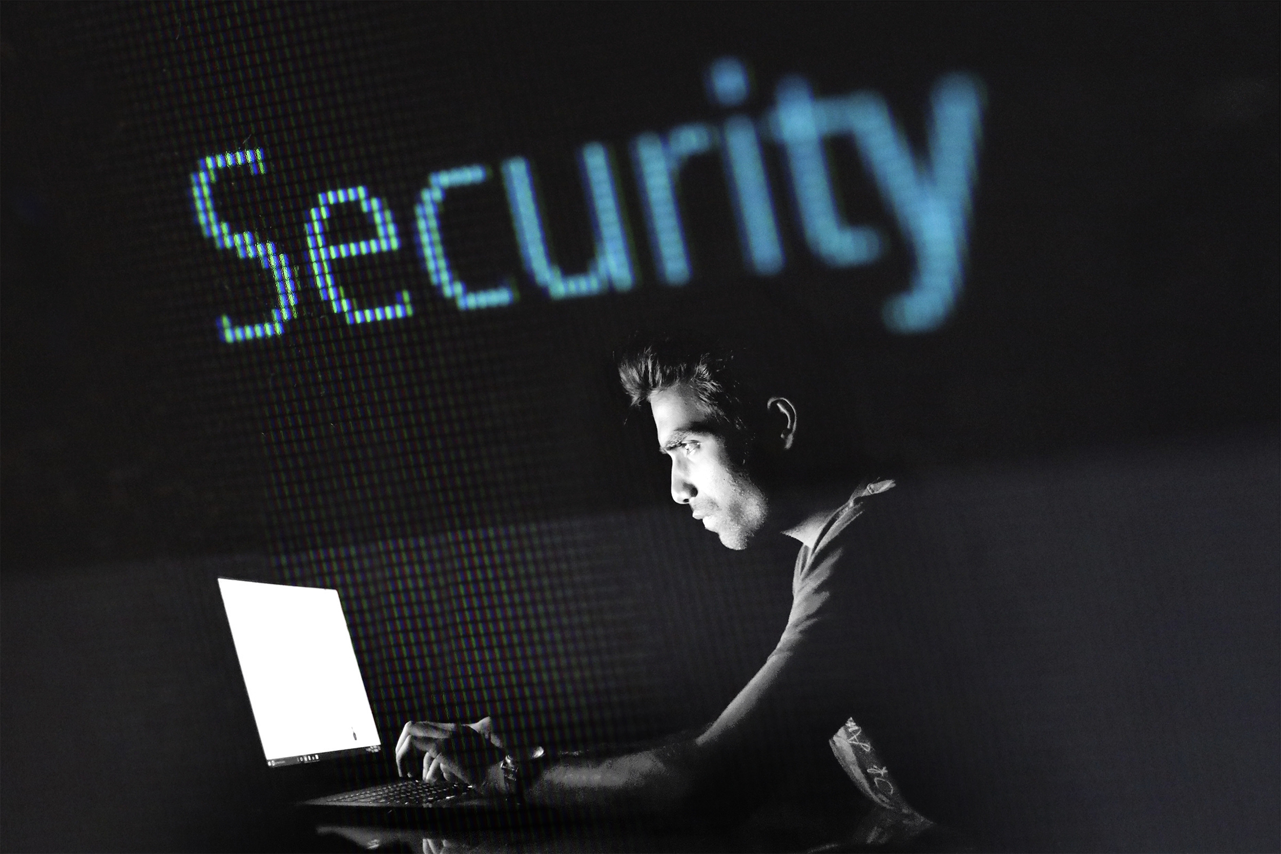 Man working on a laptop with security displayed above his head