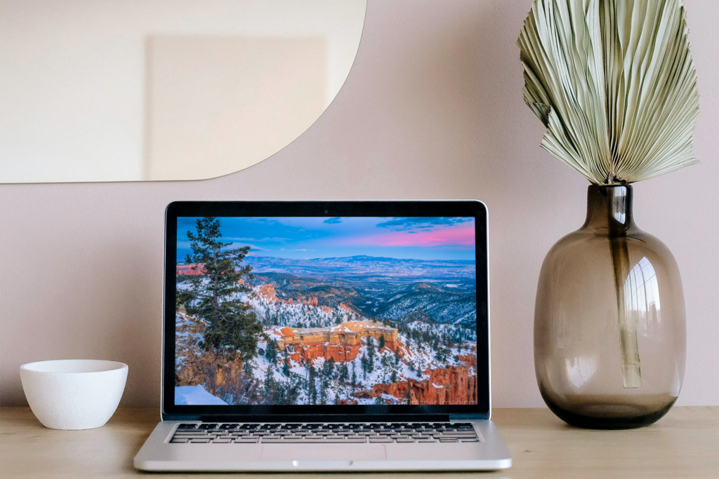 Image of a laptop computer with a landscape photo screensaver depicted on screen